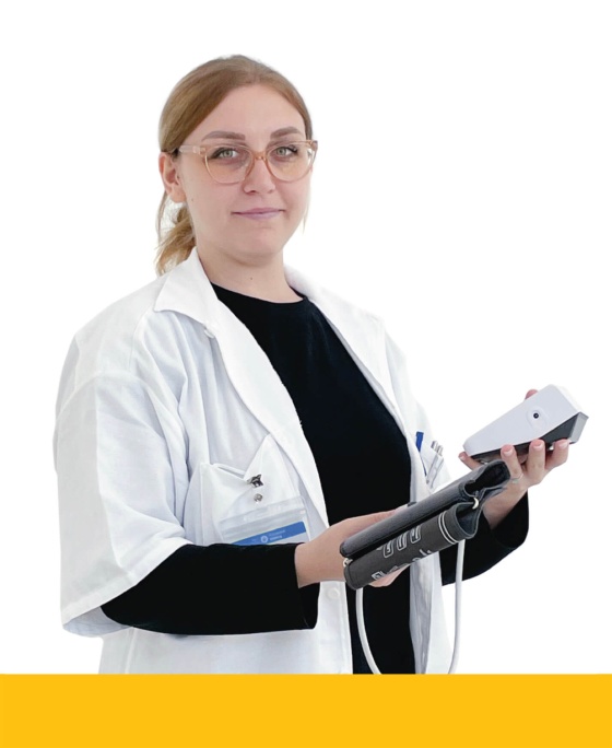 Schwaz-weiß gekleidete Frau, die ein Blutdruck-Messgerät in den Händen hält.